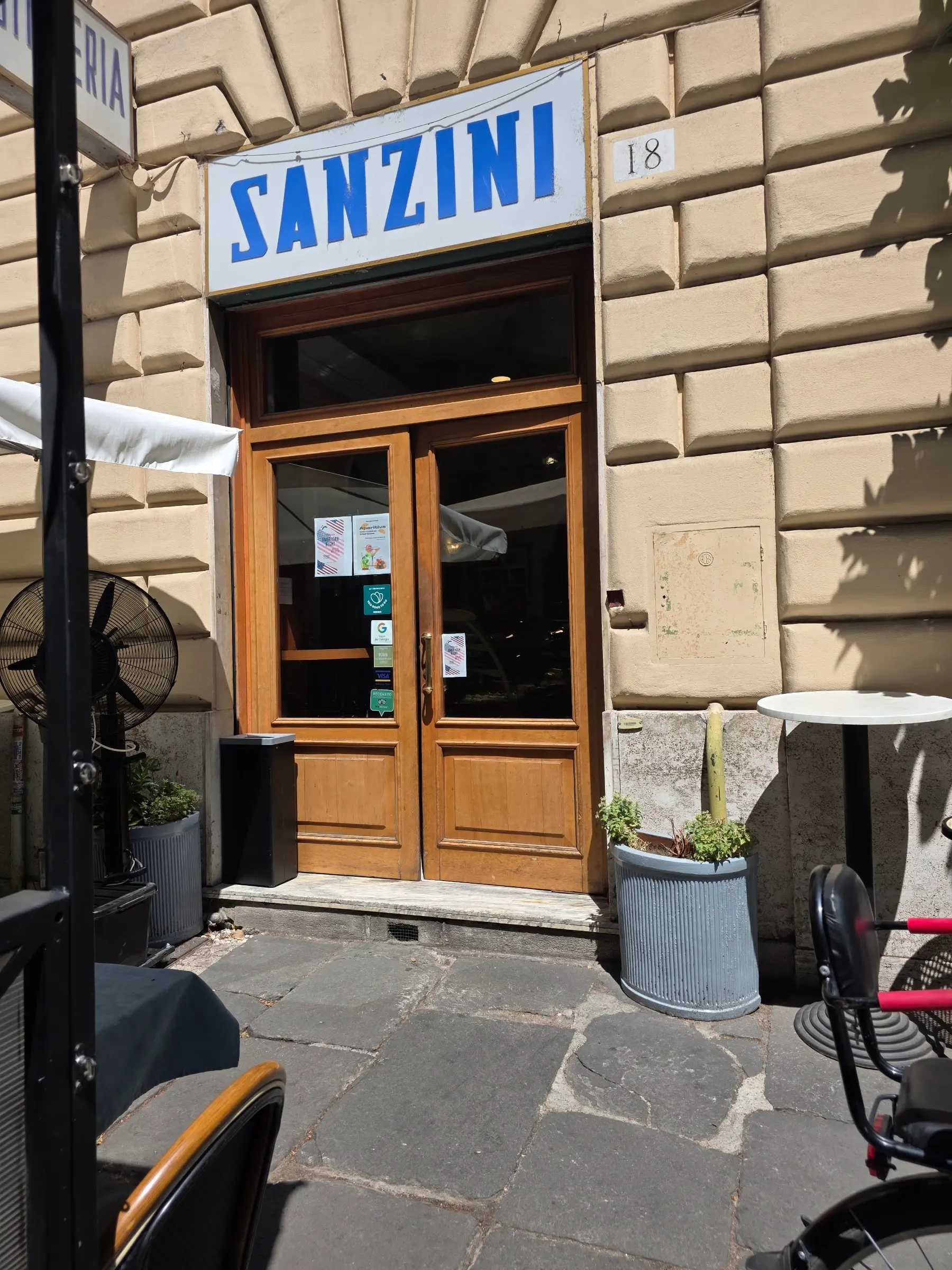 L'ingresso di Sanzini in Via Valadier 18, con l'insegna blu sopra il portone in travertino