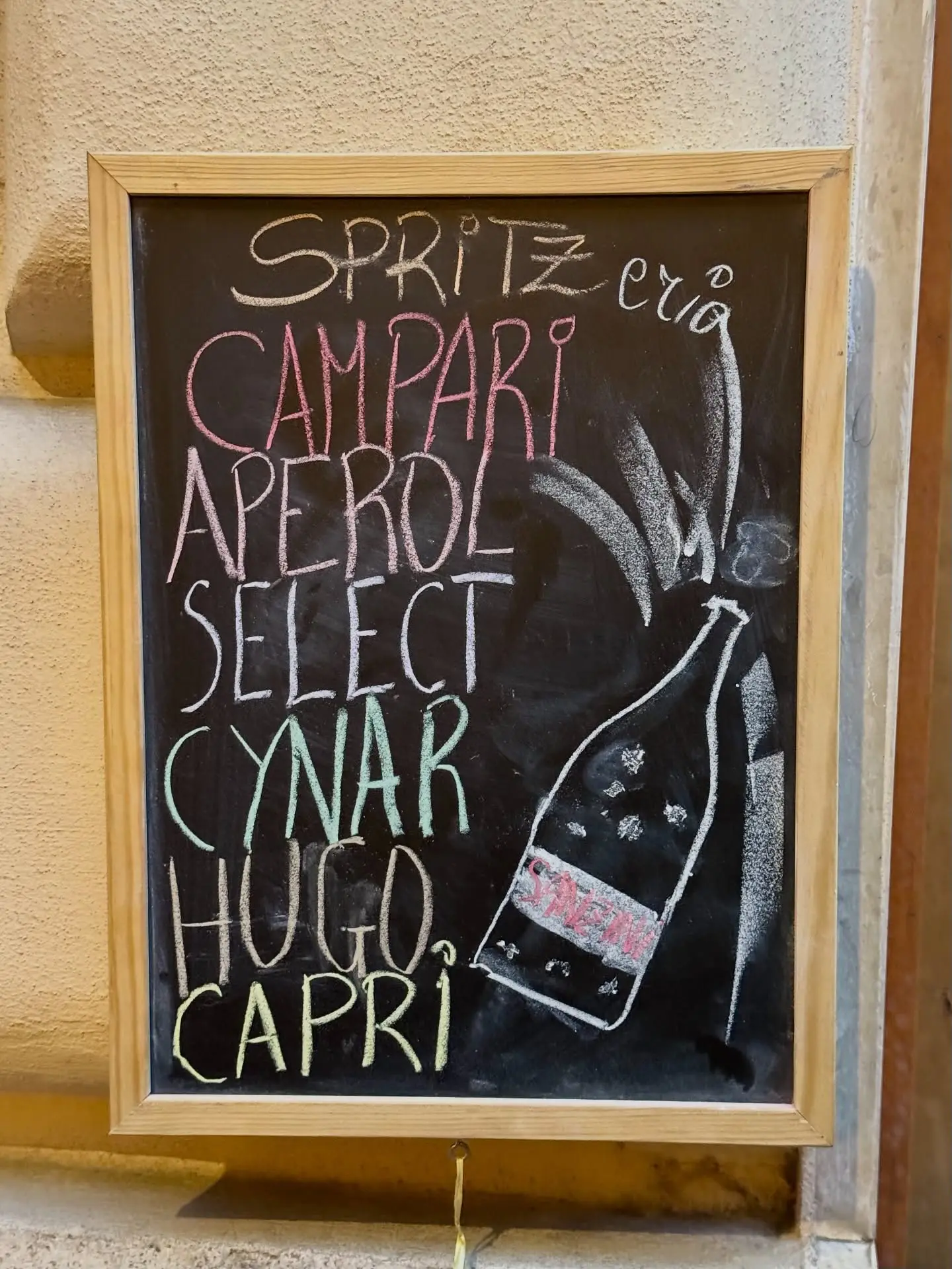 La lavagna degli spritz scritta a gesso: Campari, Aperol, Select, Cynar, Hugo