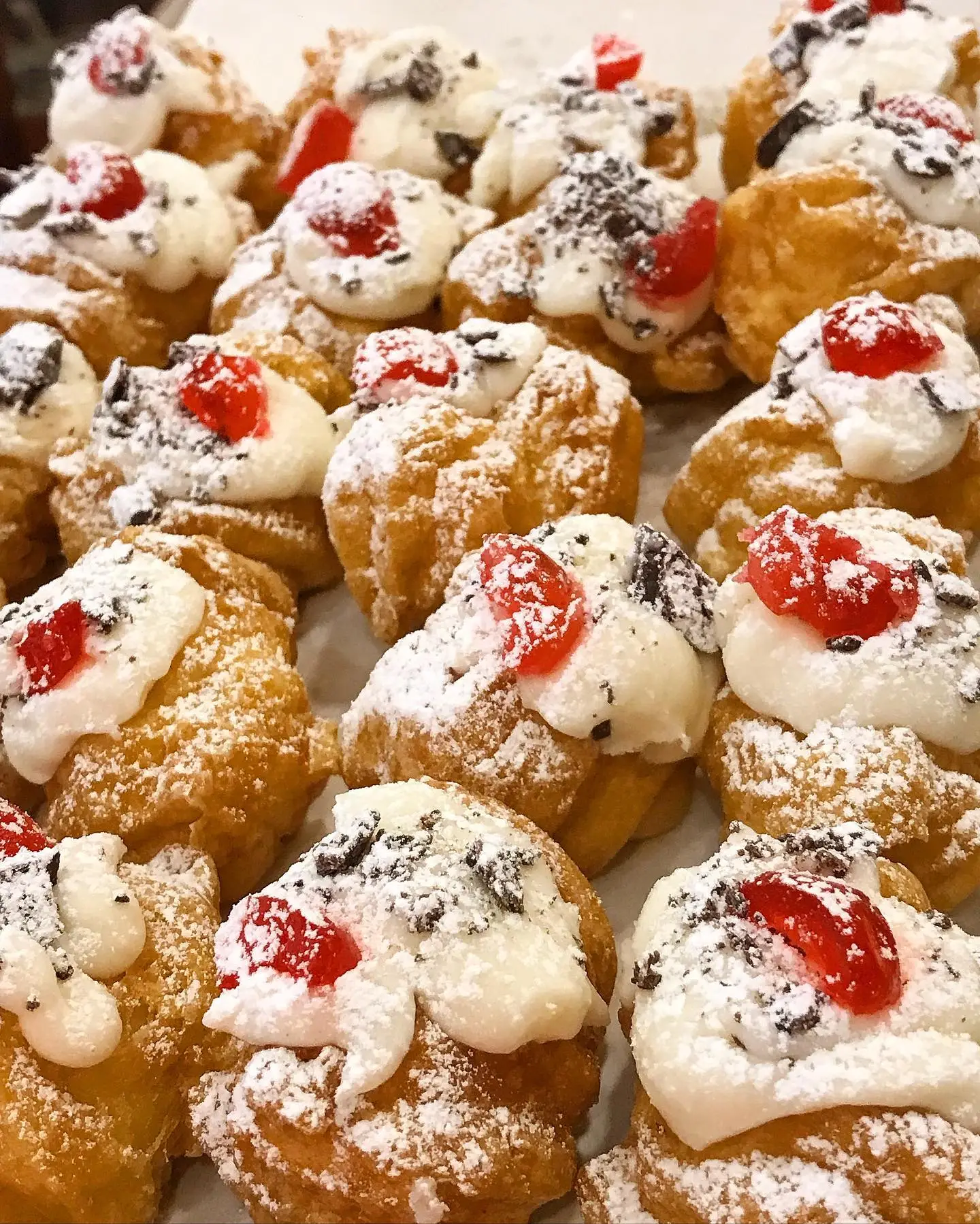 Cannoncini e pasticcini con zucchero a velo e amarene