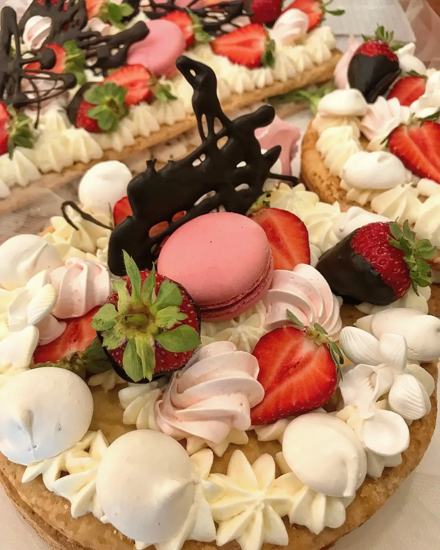Crostata con crema, fragole, macaron e meringhe